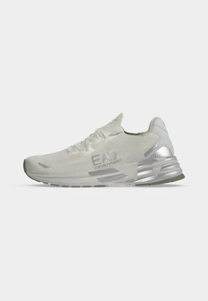 Scarpa sportiva bianca EA7 Emporio Armani con dettagli argentati e suola spessa, mostrata di profilo su uno sfondo semplice.