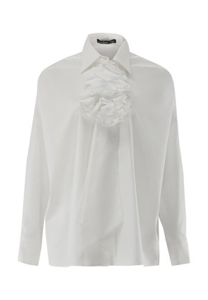 Weißes Langarmshirt mit strukturiertem Kragen und großem Stoffblumenverzierung auf der Vorderseite. Glatte Textur, lockere Passform und drapierte Gestaltung.