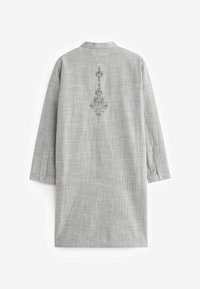 Ljusgrå långärmad skjorta med mandarin-krage, rutigt mönster och broderad blommönster på baksidan. Knappade ärmslut.