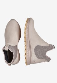 Bottines beiges à cheville avec un dessus en daim lisse, un tissu texturé au niveau du col et une semelle en caoutchouc épaisse avec un motif de semelle.