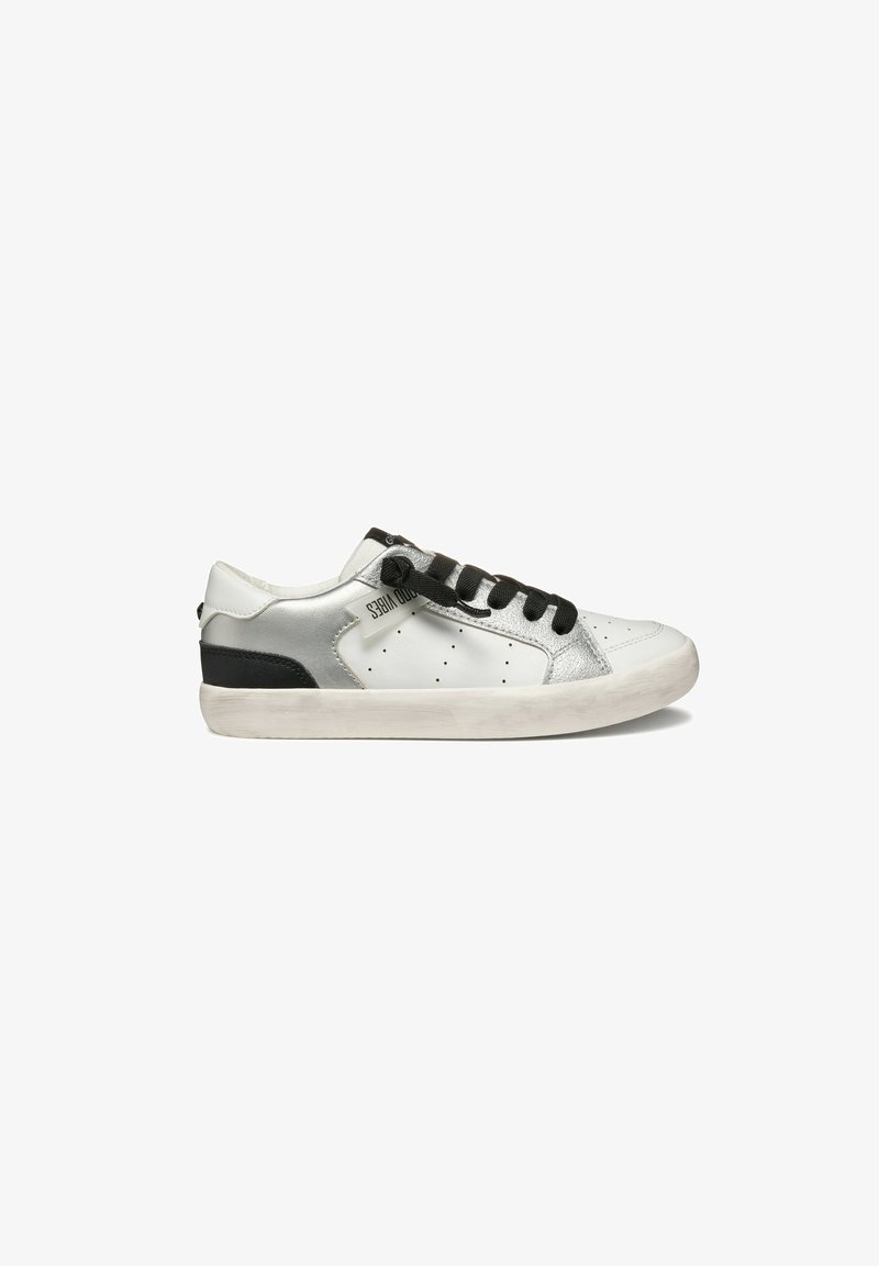 Sneaker blanche avec des accents en argent, bout rond, lacets noirs et talon noir texturé. Présente des perforations pour la ventilation. Semelle en caoutchouc.