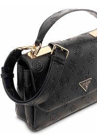 Borsa a mano in pelle nera texture con motivi in rilievo, hardware dorato, manico superiore e dettaglio del logo su una placca triangolare.