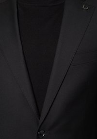 Czarna dopasowana marynarka o gładkiej fakturze, z pojedynczym guzikiem, wyrazistym klapą i subtelnym akcentem logo na kołnierzu.