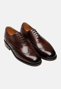 Braune Lederanzugschuhe mit Broguemuster, ausgestattet mit einer glatten Oberfläche, Schnürverschluss und einem runden Zehenbereich.