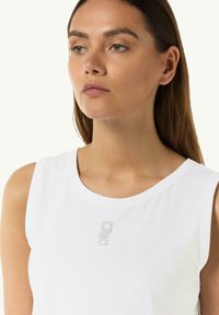Biały top bez rękawów z okrągłym dekoltem. Posiada subtelne logo w jasnoszarym kolorze na klatce piersiowej. Gładki materiał bawełniany, dopasowany krój.