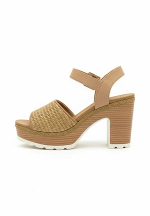 Sandale à plateforme beige avec bride avant tissée, bride de cheville ajustable, talon bloc en bois épais et semelle blanche à rainures.