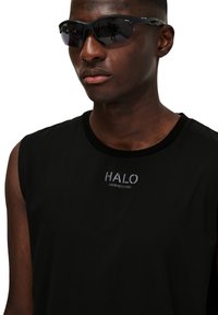 Svart ärmlös tröja med rundad halsringning och "HALO"-logotyp i silver. Kommer med svarta sportiga solglasögon med wraparound-design.
