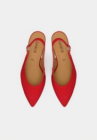 Κόκκινα slingback παπούτσια με μυτερή μύτη και λεία σουέντ υφή. Διαθέτουν μεταλλική αγκράφα στο λουράκι. Εσωτερικά έχουν ταμπά επένδυση και σήμανση.