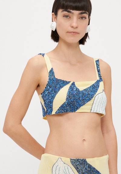 Top recortado con patrón de lentejuelas azules sobre tela amarilla, con tirantes anchos y escote cuadrado. Acentos texturizados en azul claro.