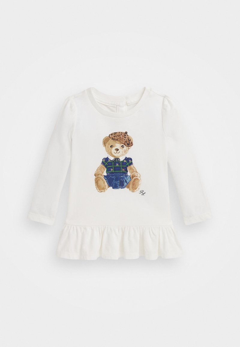 Dolga bela obleka s dolgimi rokavi, ki vključuje grafiko medvedka v karirastem oblačilu z beretko v leopardjem vzorcu ter nabranim spodnjim robom.