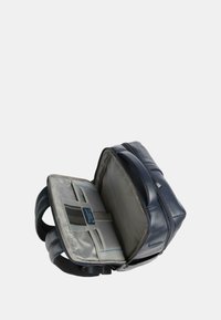Zaino in pelle blu navy con interno grigio, dotato di apertura con zip, tasche interne e spallacci regolabili. Esterno texturizzato.