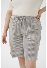 Shorts rayés avec une taille élastique et un cordon de serrage en crème et marine. Comprend des poches latérales et une coupe ample pour le confort.