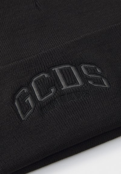 Črn pleten klobuk z vgraviranim logotipom "GCDS". Tkanina izgleda mehka, z rebrasto teksturo in brezšivno zasnovo.