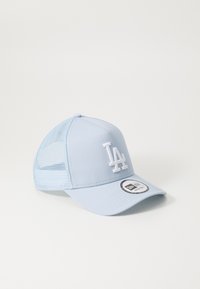 Gorra de color azul claro con una parte delantera sólida, parte trasera de malla y logo "LA" bordado en blanco. Cuenta con un visor curvo y una etiqueta negra de tamaño en la parte inferior.