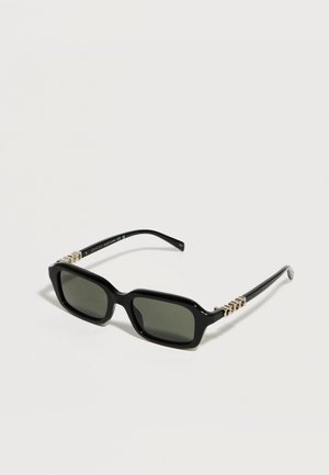 Gafas de sol rectangulares negras con lentes tintadas en verde y detalles metálicos con el logo de Gucci en las varillas, mostradas sobre un fondo blanco.