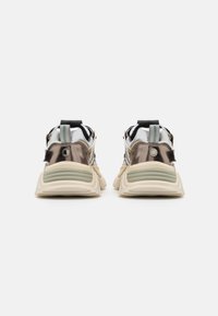 Metalen sneakers met een chunky ontwerp; voorzien van een crèmekleurige zool, zilveren accenten en een lichtgroene trekband bij de hiel.
