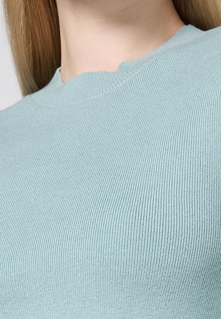 Lichtgroene ribgebreide top met een ronde halslijn, een gladde textuur en een getailleerd ontwerp. De stof heeft een subtiele stretch voor comfort.