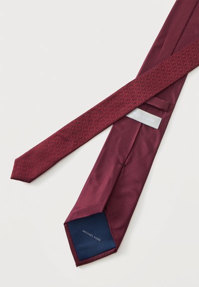 Cravate Michael Kors rouge foncé avec un motif subtil à l'avant et un dos uni, posée à plat sur un fond clair.