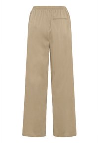beige široké kalhoty s elastickým pasem. Obsahují jednu zadní kapsu a hladkou, měkkou strukturu. Čistý design, bez dalších akcentů.