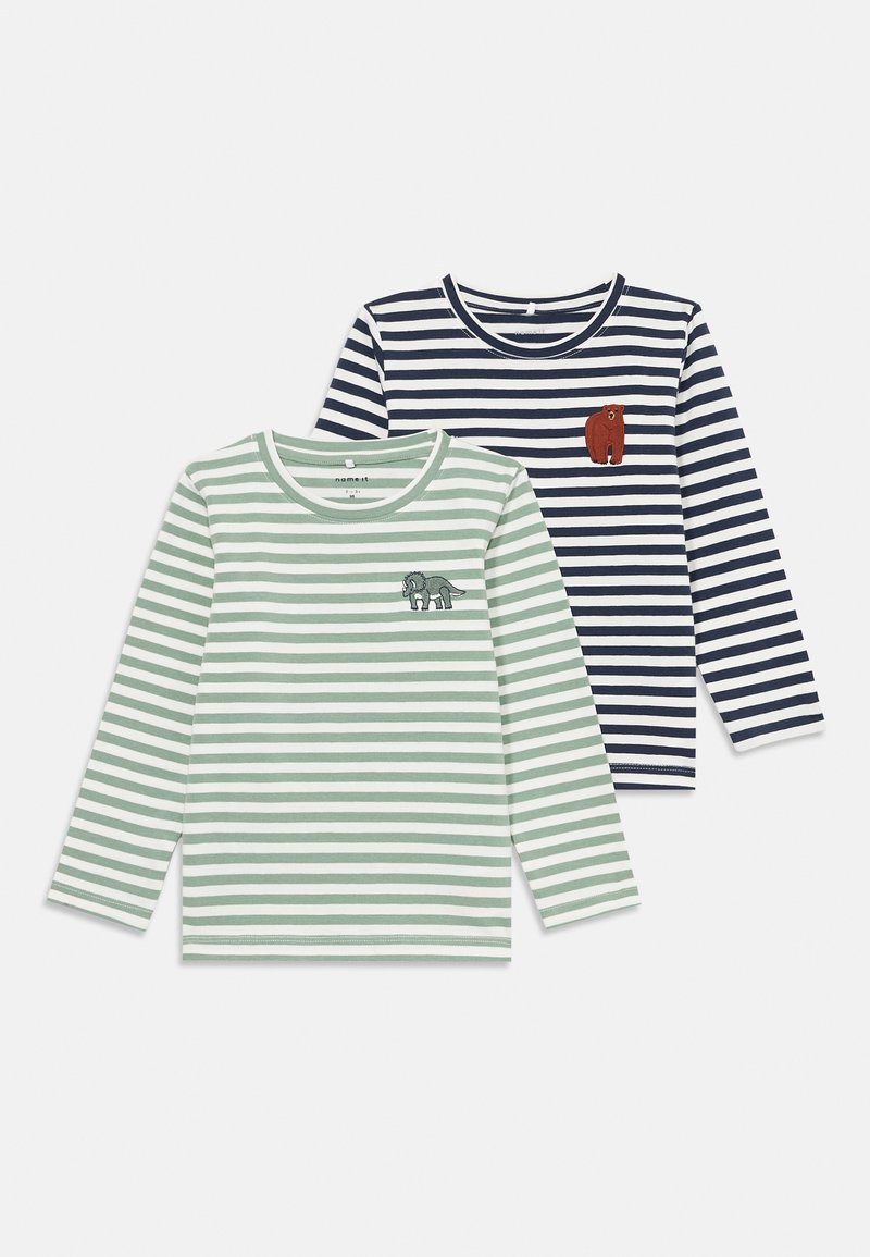 Zwei langärmelige gestreifte Kindershirts, eines in Grün und Weiß mit einem Dinosaurier-Patch, das andere in Marineblau und Weiß mit einem Bären-Patch.