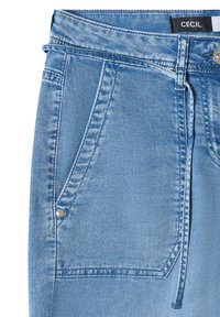 Jupe en denim bleu clair avec poches avant, passants de ceinture, bouton argenté et détails de coutures visibles sur fond blanc.