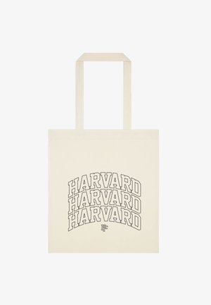 Sac cabas beige avec trois grands logos « HARVARD » en contour empilés en noir sur le devant, deux poignées en haut, fond uni.