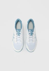 Ζευγάρι λευκών και γαλάζιων παπουτσιών τρεξίματος ASICS με υφαντό ύφασμα και κορδόνια, από ψηλά σε απλό φόντο.