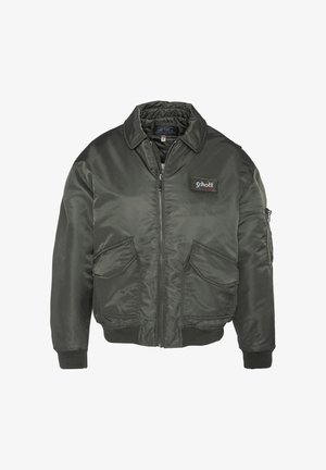 Donkergroene bomberjack met een rits aan de voorkant, geribbelde manchetten en twee voorkanten zakken. Bevat een logo-opdruk op de borst. Soepele, glanzende stof.