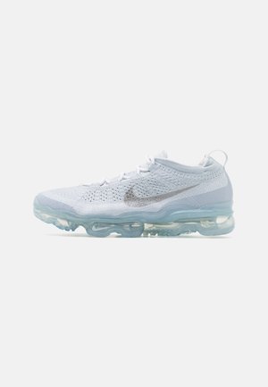 Baskets Nike blanches en maille avec semelle coussinée d'air bleue translucide et logo swoosh gris sur le côté, vues de l'extérieur.