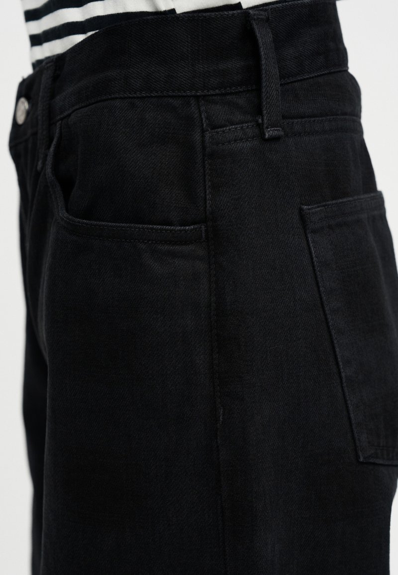 Pantaloni in denim nero con vestibilità dritta, dotati di una tasca laterale, tessuto strutturato e un design pulito della vita.