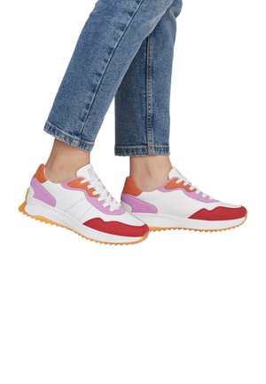 White sneakers with red, pink, and orange accents, textured rubber sole, round toe, and lace-up closure. Positioned with denim jeans.