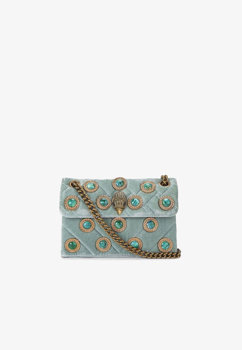 Sac à main en velours mint vert matelassé avec une bandoulière en chaîne dorée et des accents incrustés de bijoux. La fermeture est dotée d'un fermoir décoratif et orné.