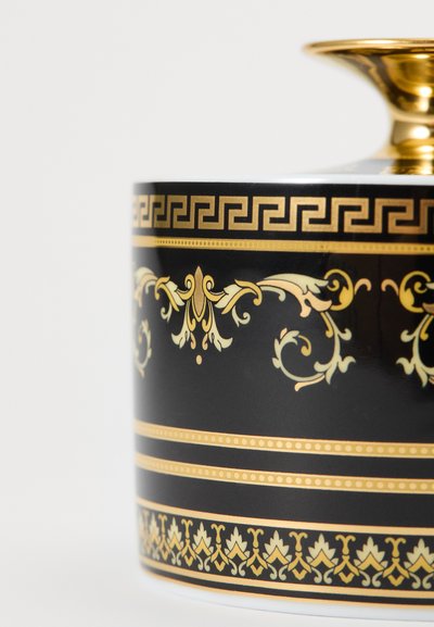Czarny ceramiczny kubek ze złotymi ozdobnymi wzorami, w tym greckimi kluczami i motywami kwiatowymi, z błyszczącą złotą obręczą na górze.