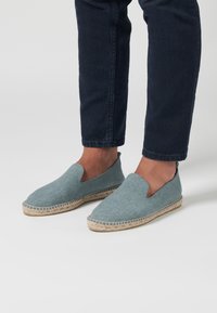 Lichtblauwe geweven espadrilles met een instapontwerp en een natuurlijke jute zool, met een gestructureerde bovenkant en open zijkanten voor ademend vermogen.
