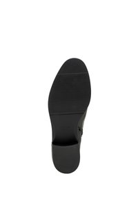 Czarna skórzana podeszwa buta z fakturowanym bieżnikiem, zaokrąglonym obcasem i wytłoczonym logo. Gładki materiał z minimalnymi detalami.