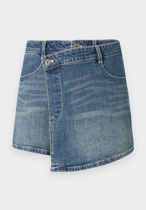 Mini-jupe asymétrique en denim bleu avec deux boutons avant et poches, présentant un effet délavé et des détails de surpiqûre.