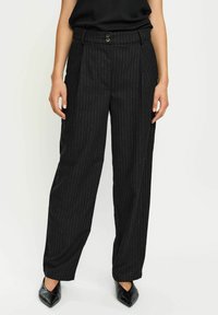 Zwarte gestreepte broek met een hoge tailleband, twee knopen en een relaxte fit. Draag het met puntige zwarte hakken voor een complete look.