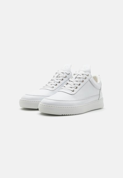 Valge nahast spordijalatsid sileda viimistlusega, ümarate varvastega, metallist silmadega ja tekstureeritud kummitaldaga. Minimalistlik disain koos peente brändingutega.