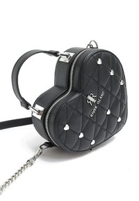 Černá kabelka ve tvaru srdce vyrobená z prošívané kůže, s stříbrným zipem a ozdobami ve tvaru srdce. Součástí je odnímatelný řetězový popruh na rameno.