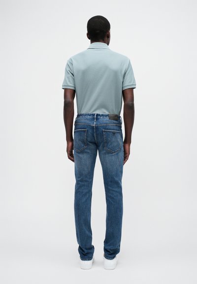 Ανοιχτό μπλε πόλο μπλουζάκι με κοντά μανίκια σε συνδυασμό με σκούρα μπλε στενά τζιν. Απλός σχε�διασμός, με λεία υφή και ελάχιστες λεπτομέρειες.