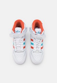 High-top sneakers with a white leather exterior, featuring red and blue stripes, perforated toe box, and orange padded interior.