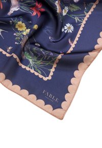 Écharpe en soie avec un fond bleu marine orné d'illustrations florales et animales colorées. Fini avec une bordure beige à motifs en forme de scallop et le logo "FABLE ENGLAND".