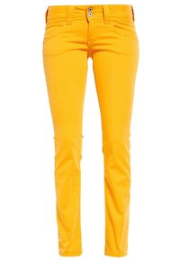 Jeans de algodón amarillos con un diseño de corte slim, que cuentan con dos bolsillos delanteros y dos traseros. Cerrados con dos botones plateados. Textura suave.