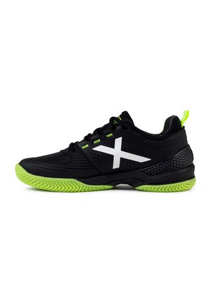 Des chaussures de sport noires avec un dessus texturé, des accents verts et un logo X blanc. Elles sont équipées d'une semelle en caoutchouc verte avec un motif en zigzag.