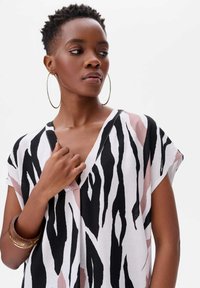 Korte mouwen shirt in lichtgewicht stof met een zwart, wit en roze dierenprint patroon en een V-hals ontwerp.