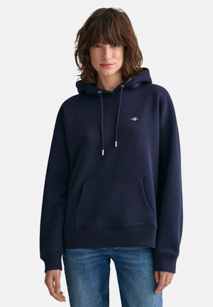 Marineblaues Hoodie mit Kordelzug, frontalem Taschen und gerippten Bündchen. Mit einem kleinen Logo auf der Brust. Weiches, strukturiertes Material.