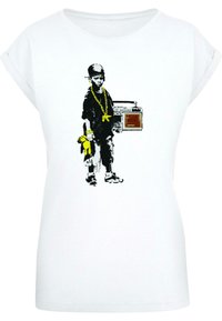 White T-shirt features a graphic of a child holding a boombox, wearing a black shirt and gold chain, with a yellow toy.