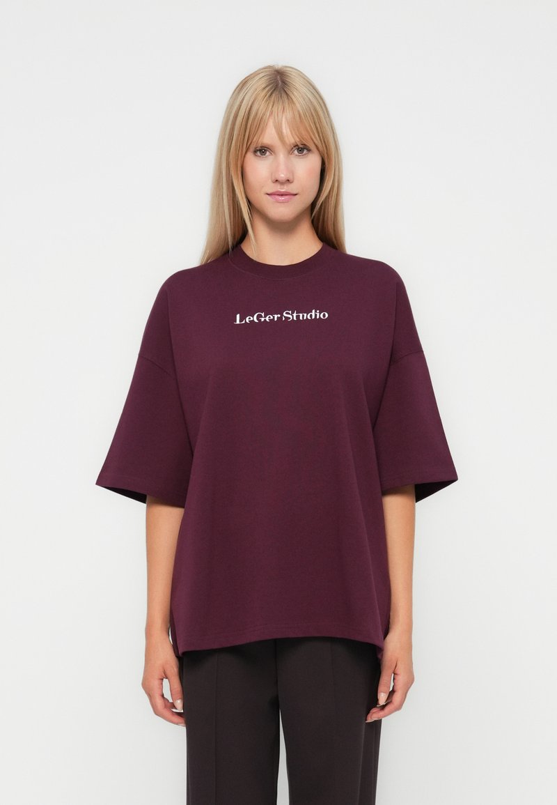 Burgundy oversized t-shirt made of cotton, featuring a round neckline and short sleeves. Text "LeGer Studio" printed in white on the front.
