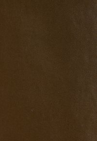 Tessuto marrone con una texture a coste, che mostra una superficie uniforme e una colorazione omogenea su tutto il materiale.