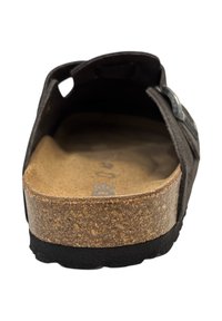Birkenstock met een kurken voetbed, textuur bovenkant, open achterkant ontwerp en zwarte rubberen zool. Heeft een verstelbare band met metalen accent.